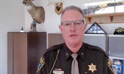  Livingston County Sheriff Mike Murphy looking at the camera in his office. He is in his brown officer uniform 