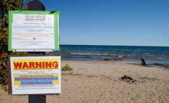 Sign warns swimmers of pathogen pollution at a northern Michigan beach.  
