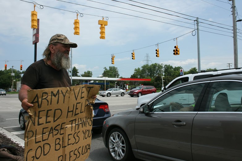 Mark Massie, 59, stands at a popular panhandling spot in Cascade Township in suburban Grand Rapids.The township is considering a law regulating panhandling. 