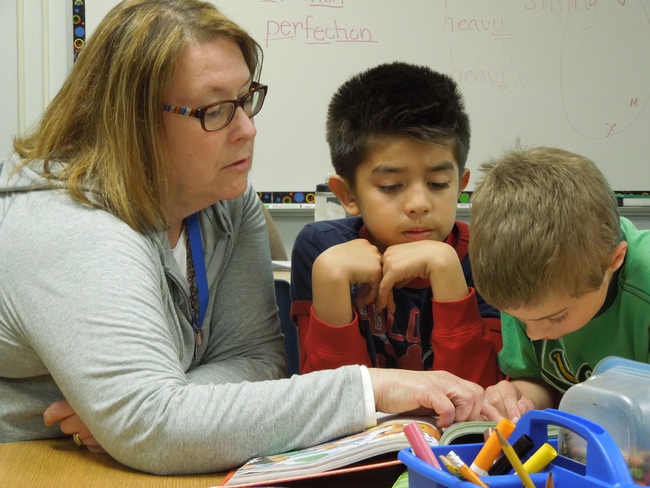 Gretchen Zalewski, a third-grade intervention teacher at Bel Air Elementary in New Brighton, Minn., works on reading skills with two students. Minnesota provides more funding to high-poverty schools than schools with more affluent students, allowing low-income schools to hire intervention teachers. “It’s the key to everything, to have enough people and time to address individual needs,” Zalewski said. (Bridge photo by Ron French)