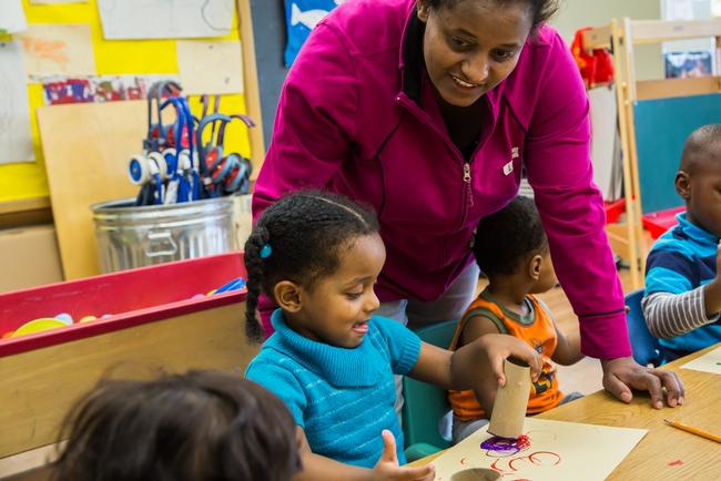Lenssa Mergerssa works with 2-year-old daughter Liya in an Early Childhood Family Education class in St. Paul, Minn. The classes, open to all Minnesota families, offer training for parents about age-appropriate play that helps children learn. The parent education component of the state policy is unique in the nation. (Bridge photo by Stephanie Rau)