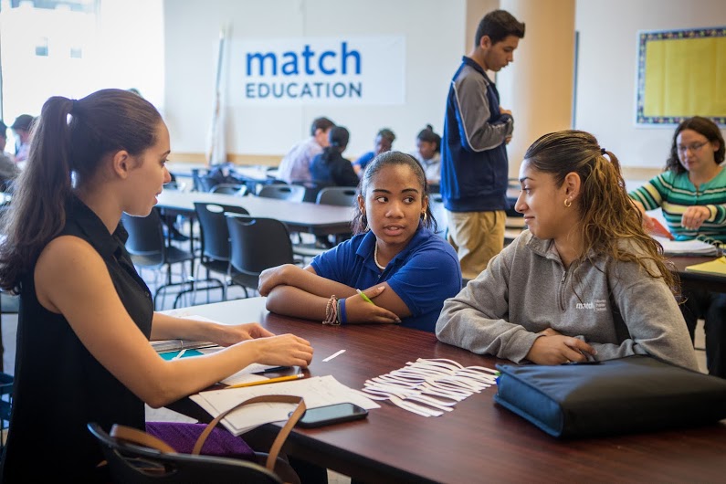 Tutor and teacher-in-training Francheska Jimenez works with two students at Match Public Charter High School in Boston. Tutors say the support they can give teenagers in their daily lives is sometimes just as critical as the academic help they provide. (photo by Aram Boghosian)