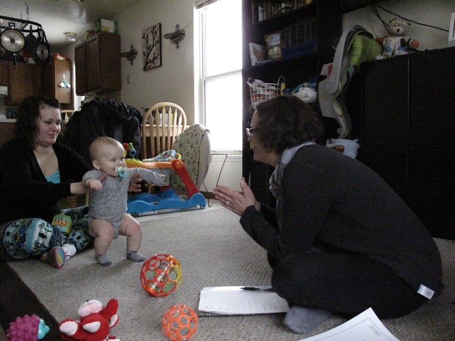 Eight-month-old Nathan Rice responds to the cooing charms of home-visitation worker Becca Boot. 