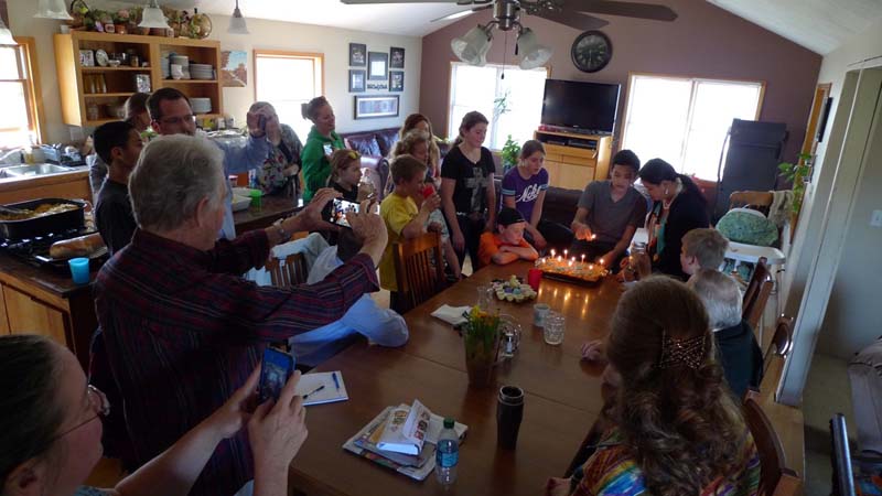 Elijah Courser, 13, prepares to blow out the candles on his birthday cake at a regular Sunday gathering of his large extended family in Lapeer. (Bridge photo by Nancy Derringer)