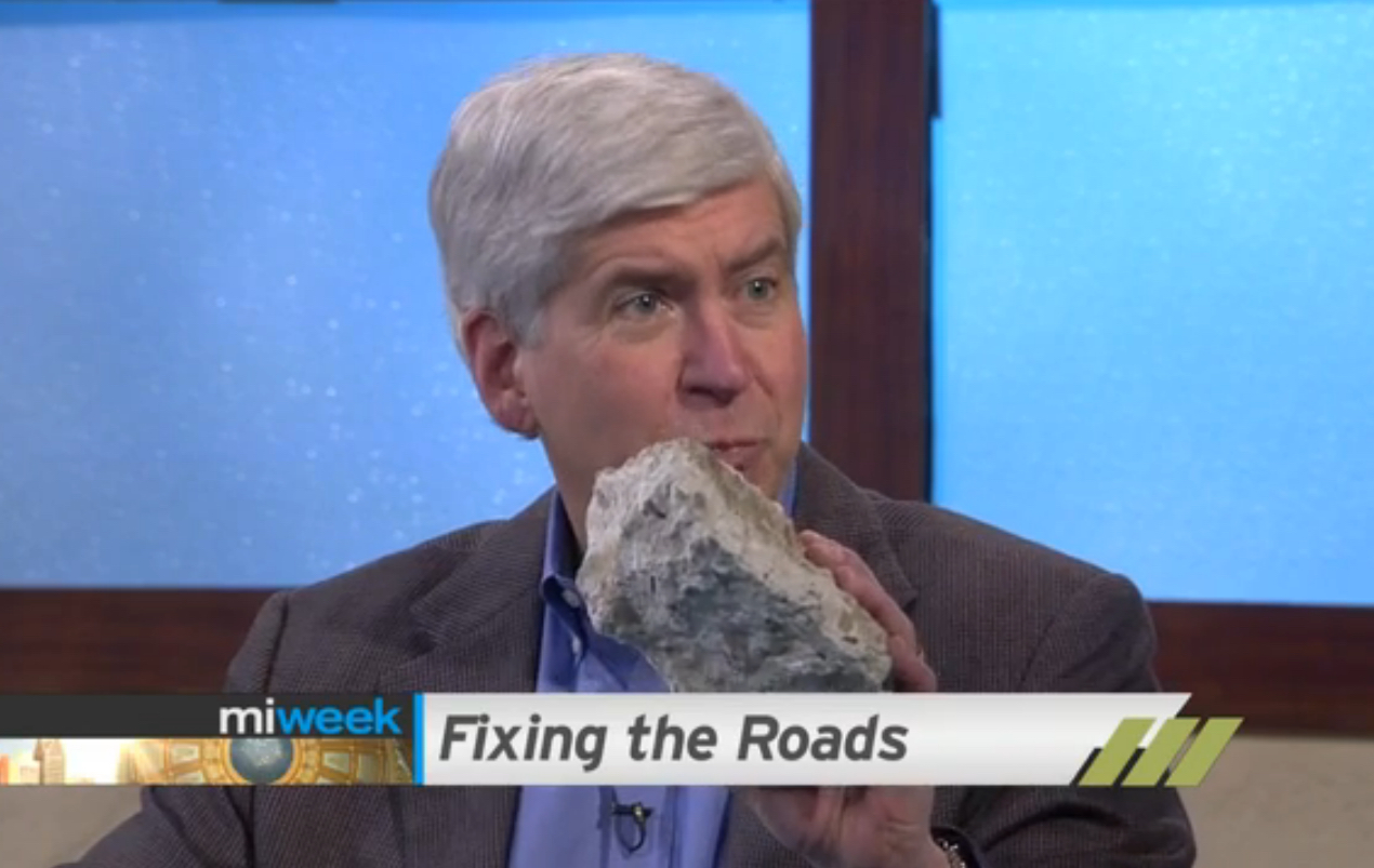 Gov. Rick Snyder has been carrying a prop around the state in his campaign for Proposal 1 – a piece of concrete from a crumbling Michigan bridge. (Screen capture from MiWeek, Detroit Public Television)