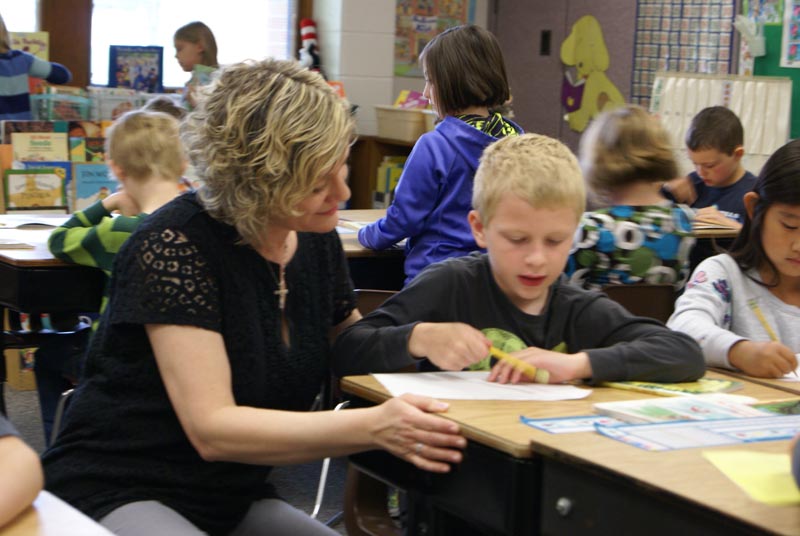 Jennifer Aalderink, a first-grade teacher at Waukazoo Elementary, helps student Benjamin McBride with his reading. Chase Barrett, a first grader at Waukazoo Elementary, reads a 