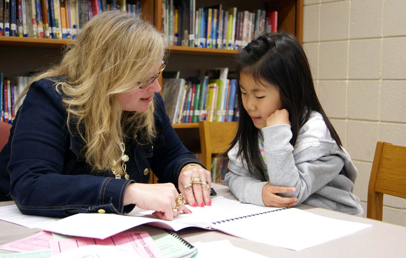 Lakeshore English teacher Denise Archer administers a DIBELS test, measuring the reading ability of first grader Lovel Kim. (Bridge photo by Pat Shellenbarger) 