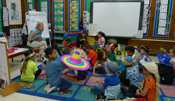 Crazy Hat Day is in full flower at Lindbergh Elementary, as teacher Tracy Wright leads a discussion with her kindergarten class. (photo by Nancy Derringer)