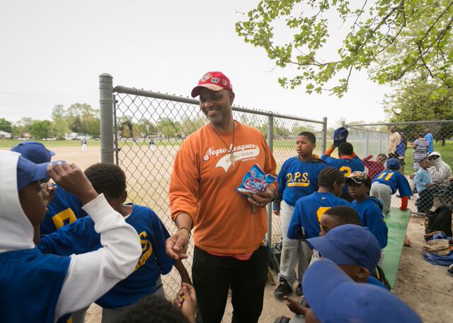 William Weir gives players "lucky" bubble gum before a baseball game on Detroit's west side. Weir uses membership on the team as a carrot to encourage respectful behavior in his social studies classes. (Bridge photo by Brian Widdis)