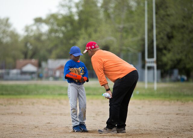Coach William Weir has a moment with 8-year-old pitcher Justin Tye at Peterson Park on Detroit's west side. Weir teaches social studies at the Schulze Academy for Technology and Arts, and many of his students play on his team. (Bridge photos by Brian Widdis)