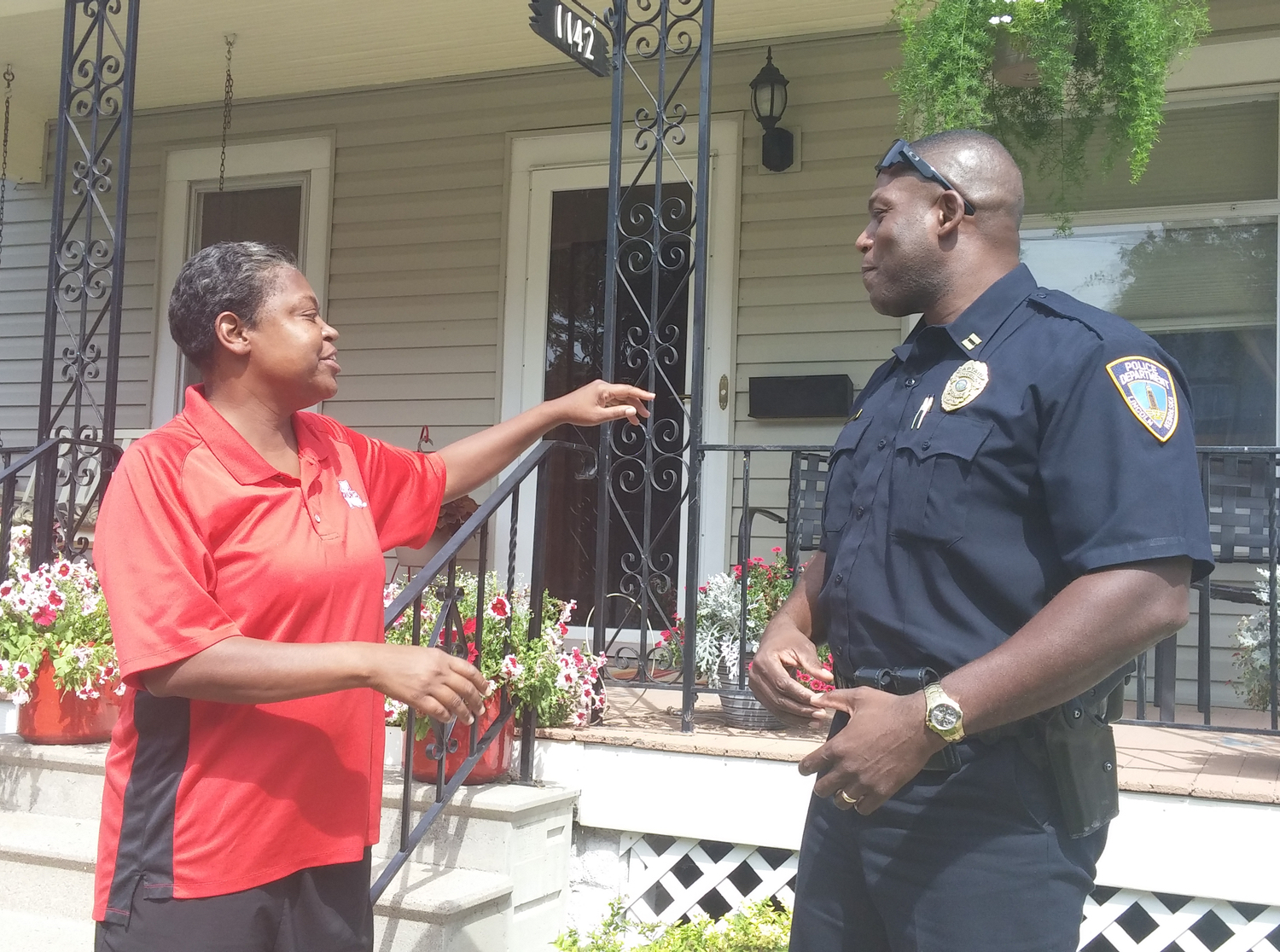 Annette McRoy talks with Capt. Anthony Butler in the North Bottoms neighborhood that she shares with students. More than two-thirds of the homes are student rentals but police have cracked down and limited the number of wild parties. McRoy, a former city council member, bought a house in the neighborhood after the crackdown reduced the number of problem houses. (Bridge photo by Mike Wilkinson)