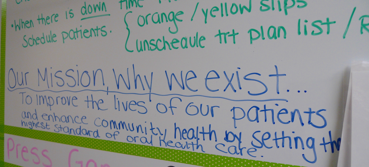 A break-room whiteboard reminds workers of the clinic’s mission. (Bridge photo by Nancy Derringer)