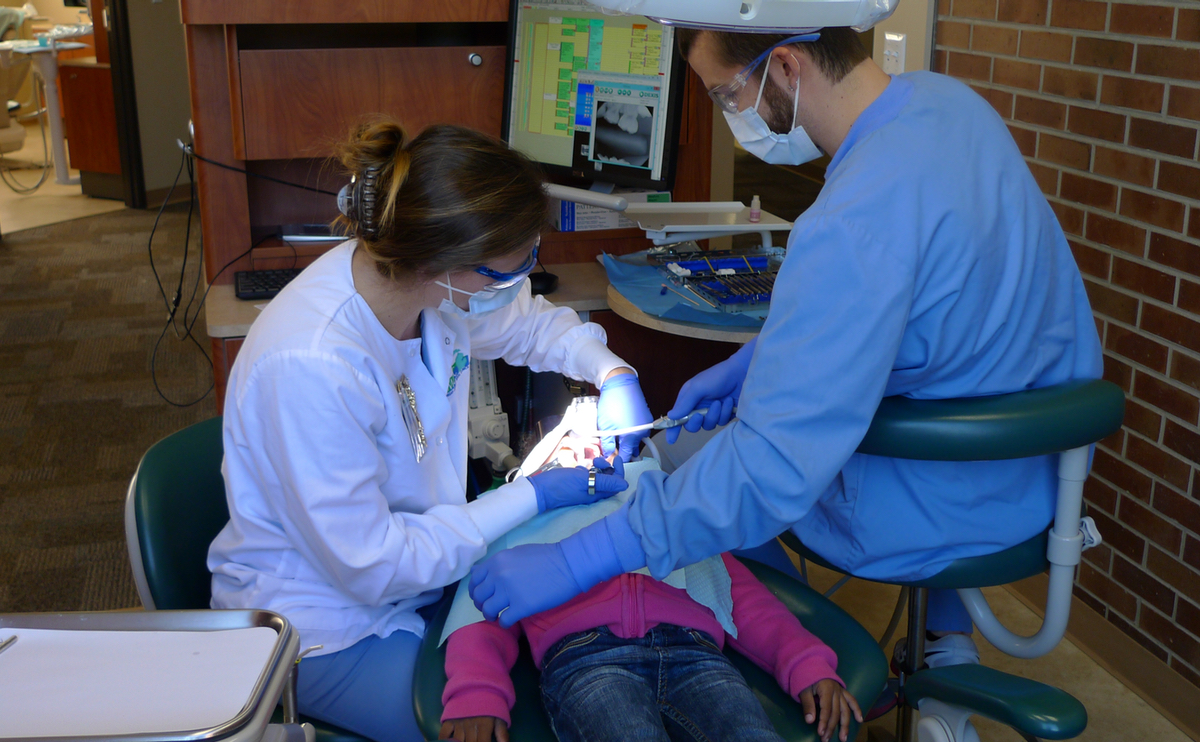 An MCDC clinic sees patients of all ages. Here, Dr. Rebekah Sheppard and assistant Bobby Laurence fill a cavity in a 4-year-old patient in Monroe. (Bridge photo by Nancy Derringer)