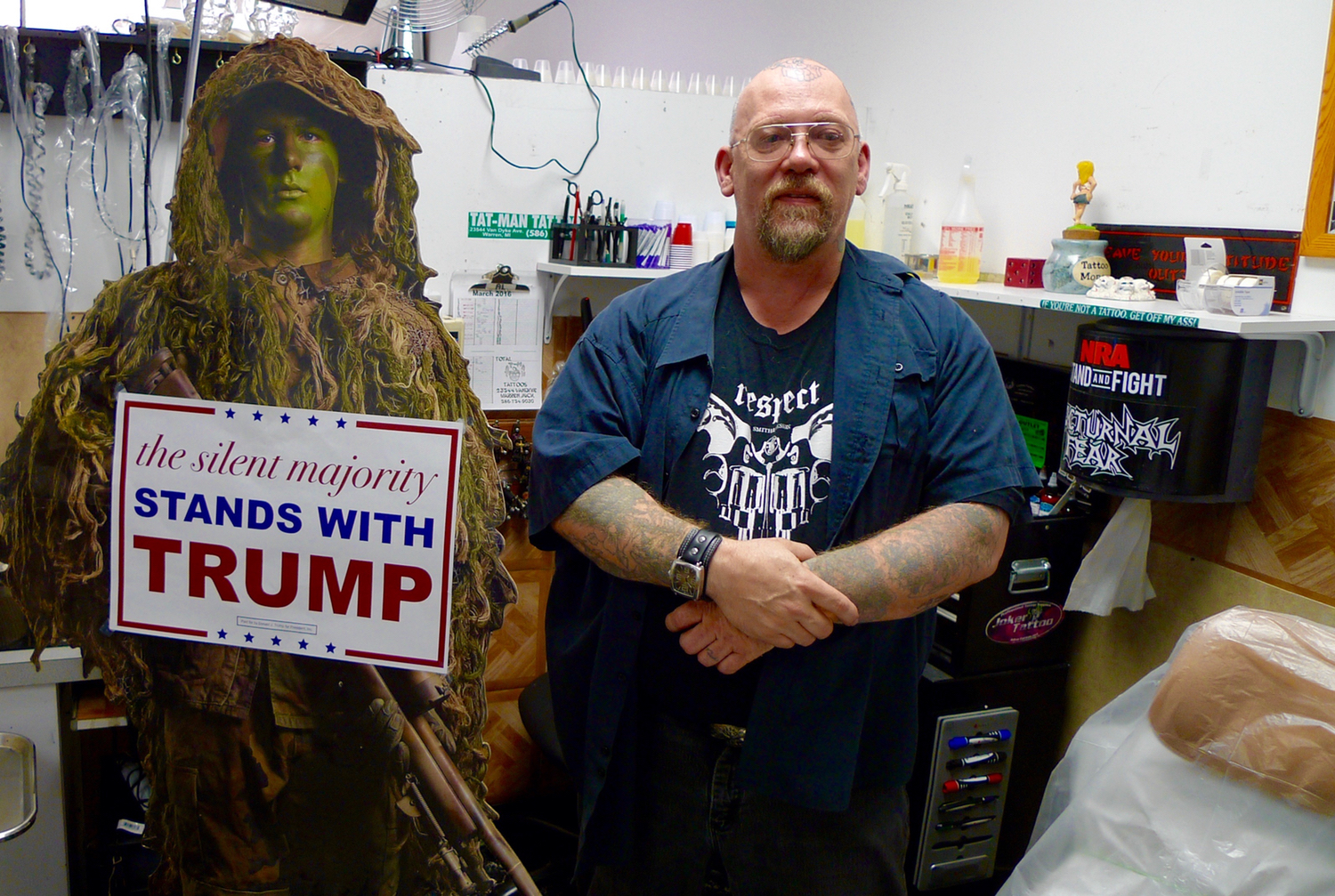 The soldier is cardboard, but Alvin Carden thinks it looks like his nephew, and as a military veteran himself, he likes the message it sends with his Trump rally sign, so he keeps it in his tattoo shop in Warren. (Bridge photo by Nancy Derringer)