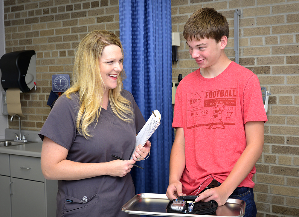 Brooke McNabb, a nurse from Scheurer Health Systems meets with a student at Laker Junior-Senior High School. Like many small districts, Laker Schools doesn’t have money in its budget for a school nurse. But unlike other districts, the local hospital provides one. (Photo courtesy Scheurer Health Systems) 