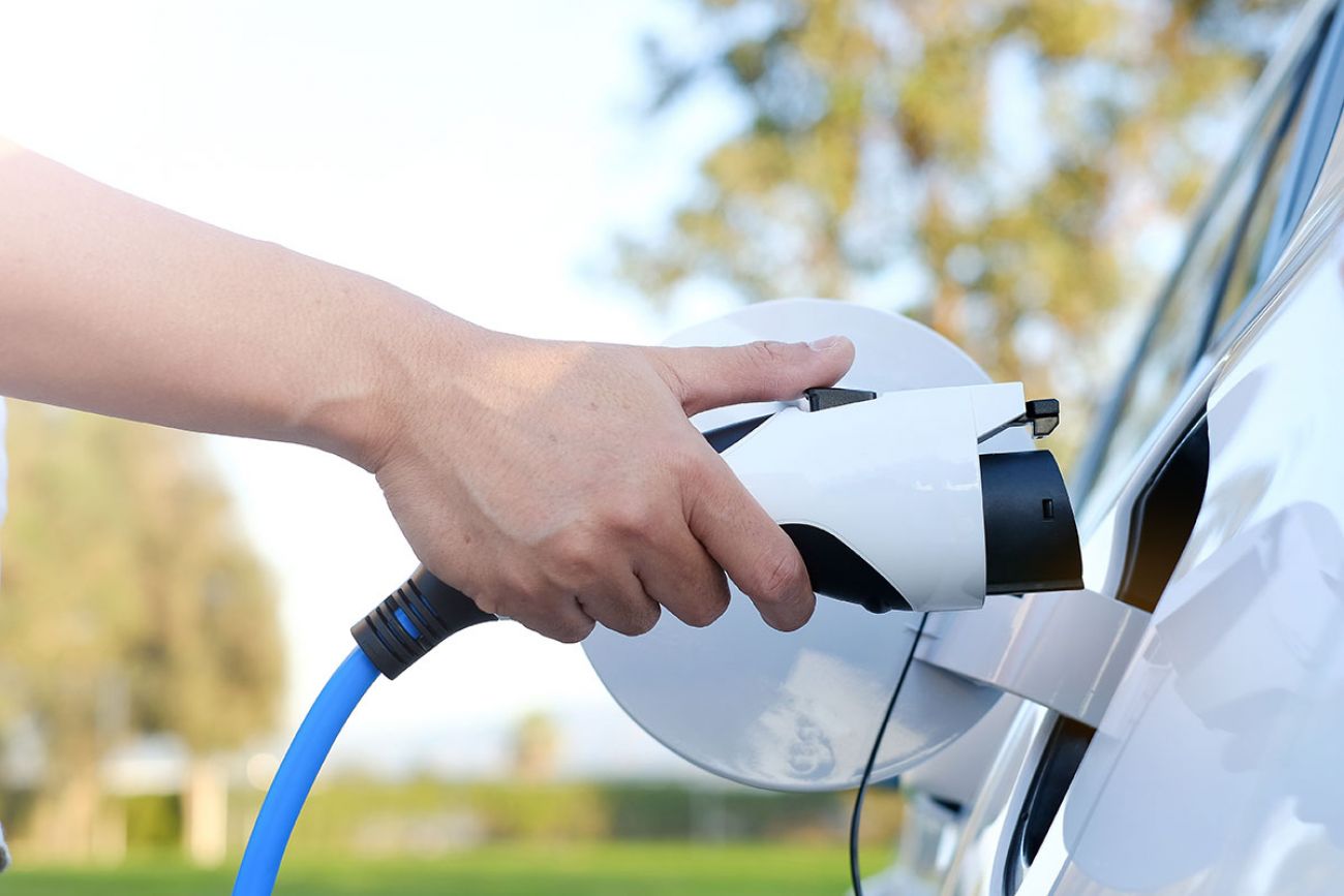 someone charging electric vehicle 