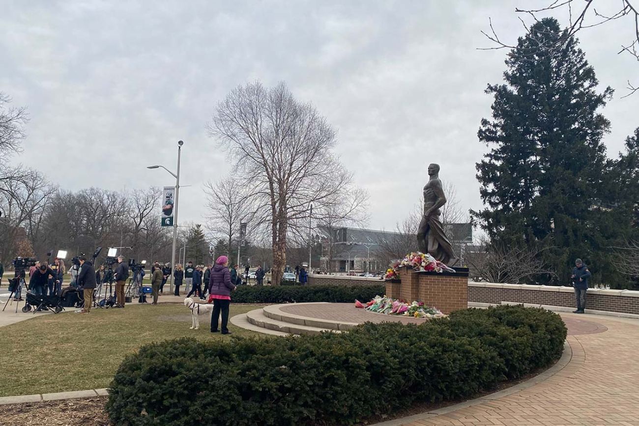 people gather around the Spartan statue 