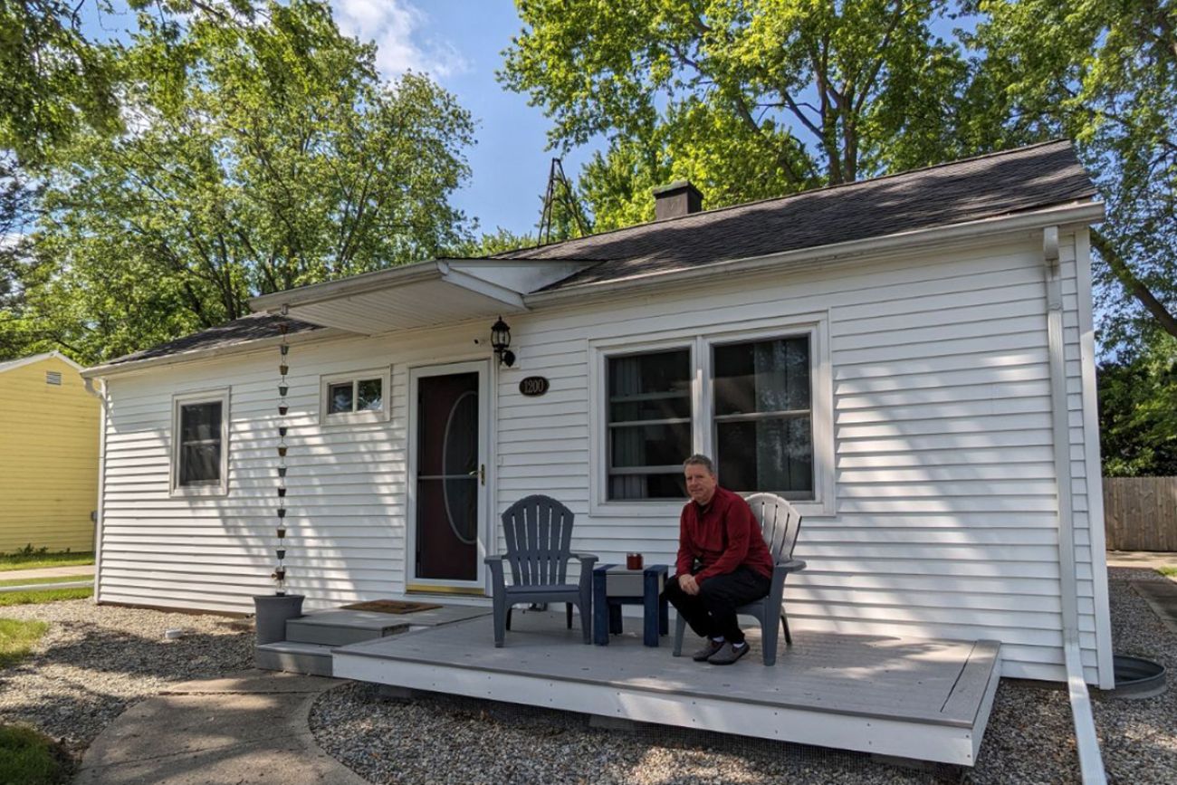 man sitting in front of house