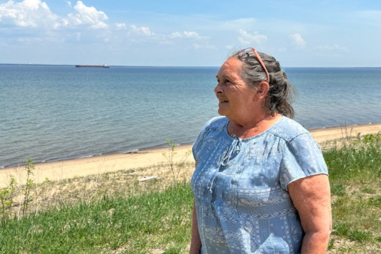 Woman stands in front of beach