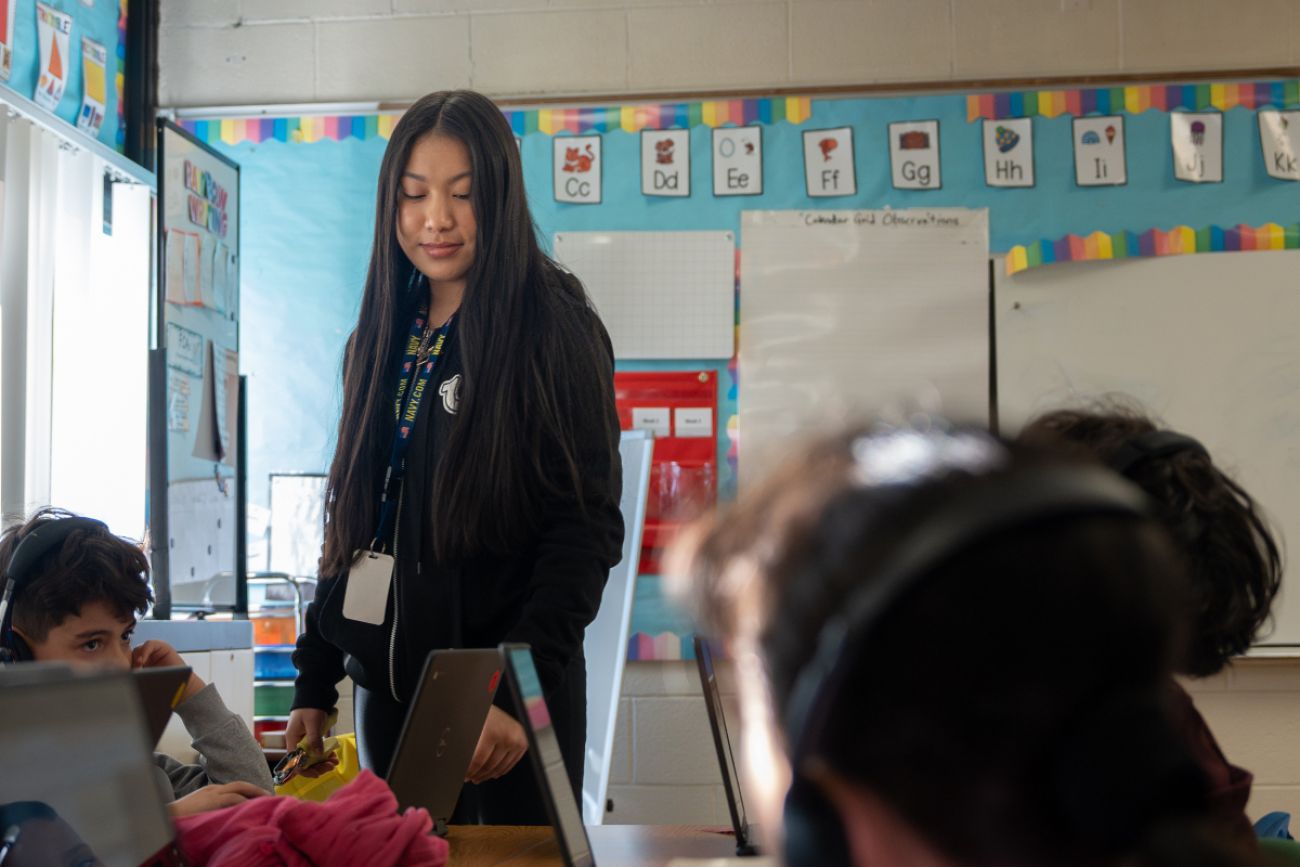 Young woman helps a student read