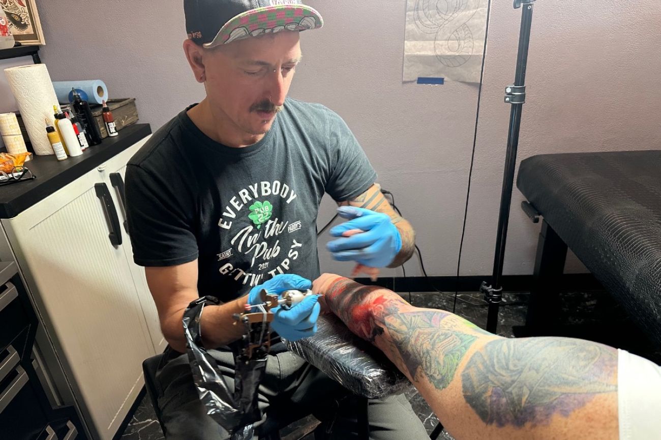Man putting a tattoo on an arm