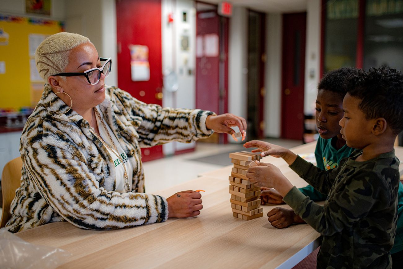 An adult plays Jenga for child