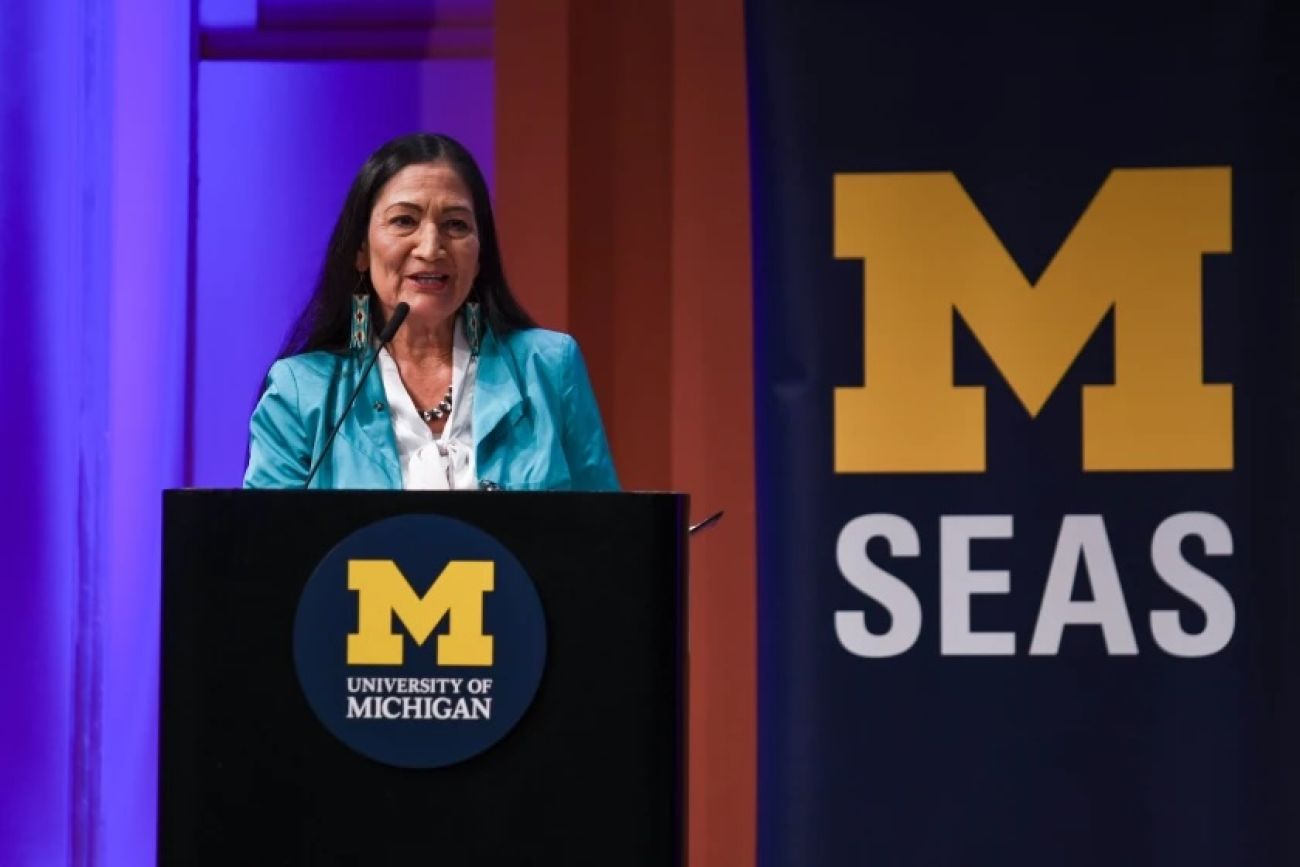 Woman stands at a podium.