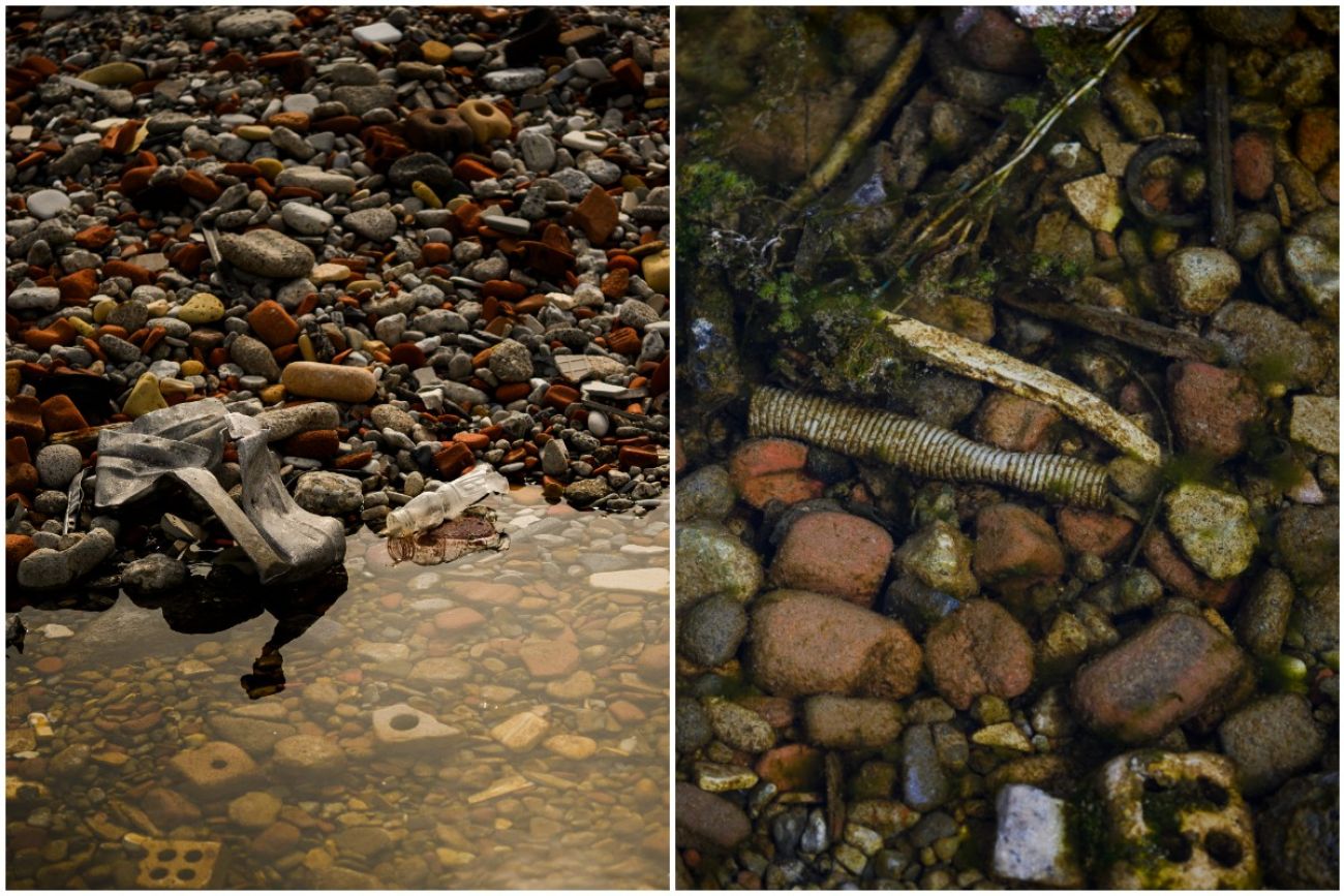 Little bits of trash in water and in rocks near the water