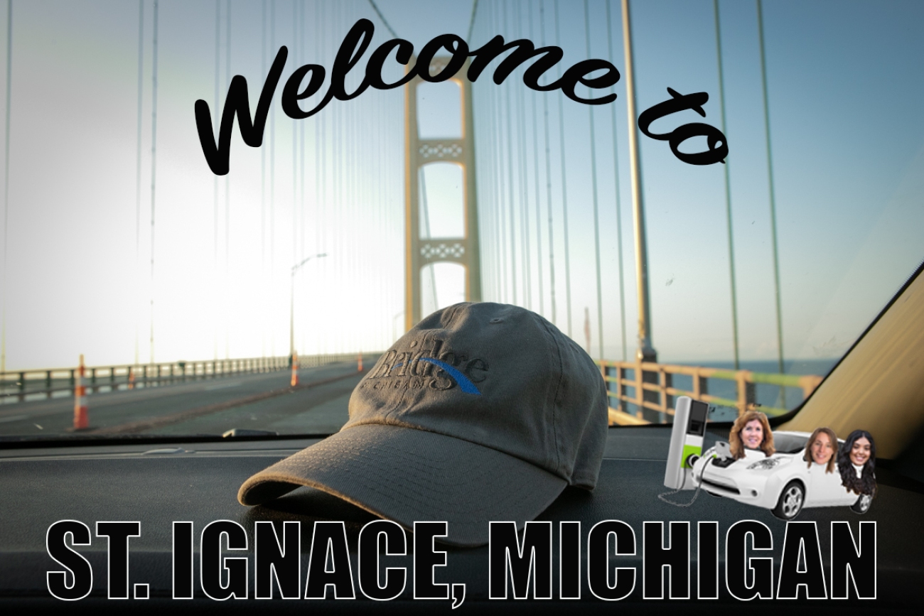Welcome to St. Ignace postcard. You can see a Bridge hat on the foreground and the Mackinaw Bridge in the background