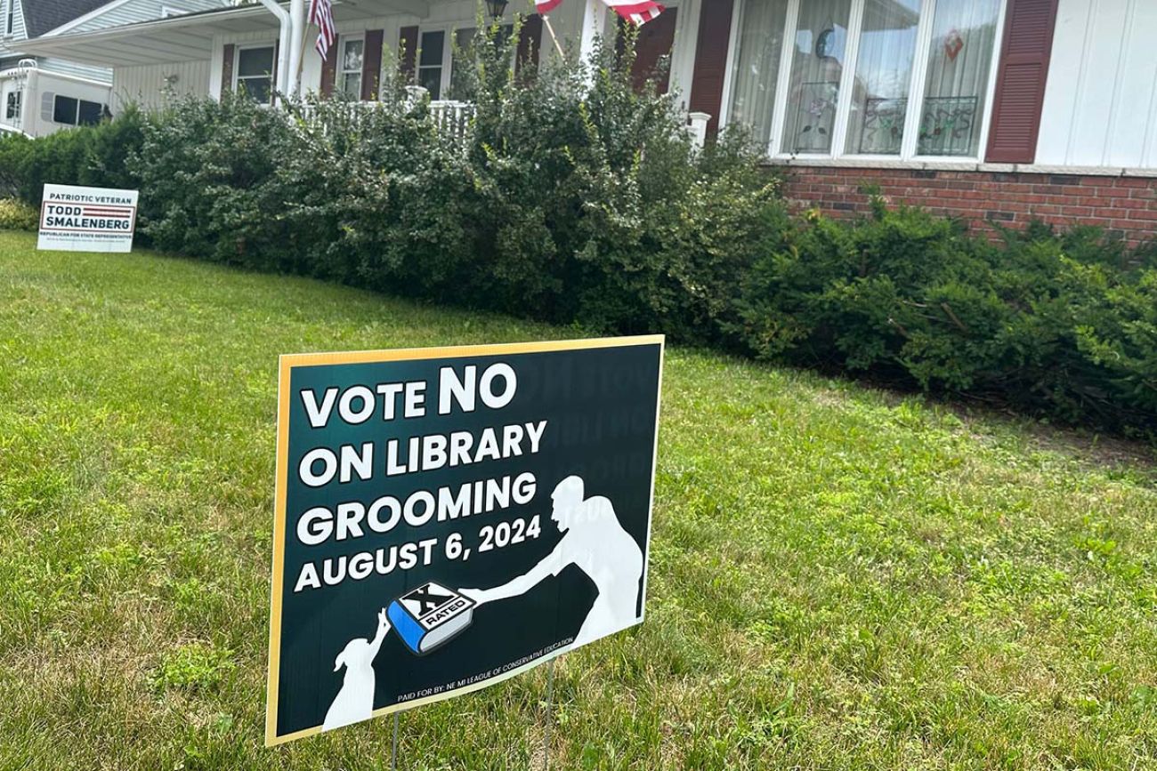 A sign in front of a home. The sign says "vote no on library grooming"
