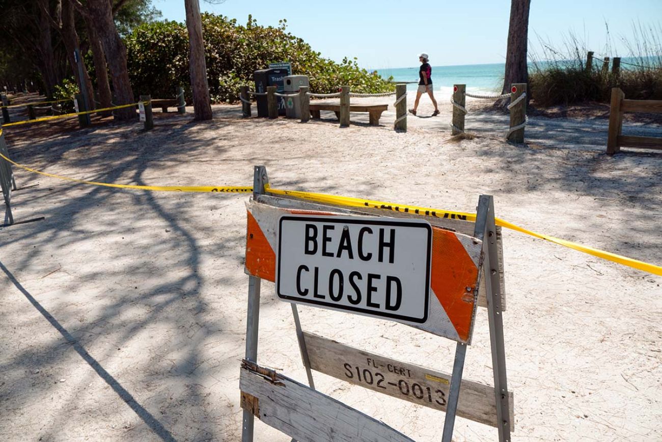 A barricade with sign is posted on Bradenton Beach Florida to warn beaches are closed for public safety during covid coronavirus pandemic