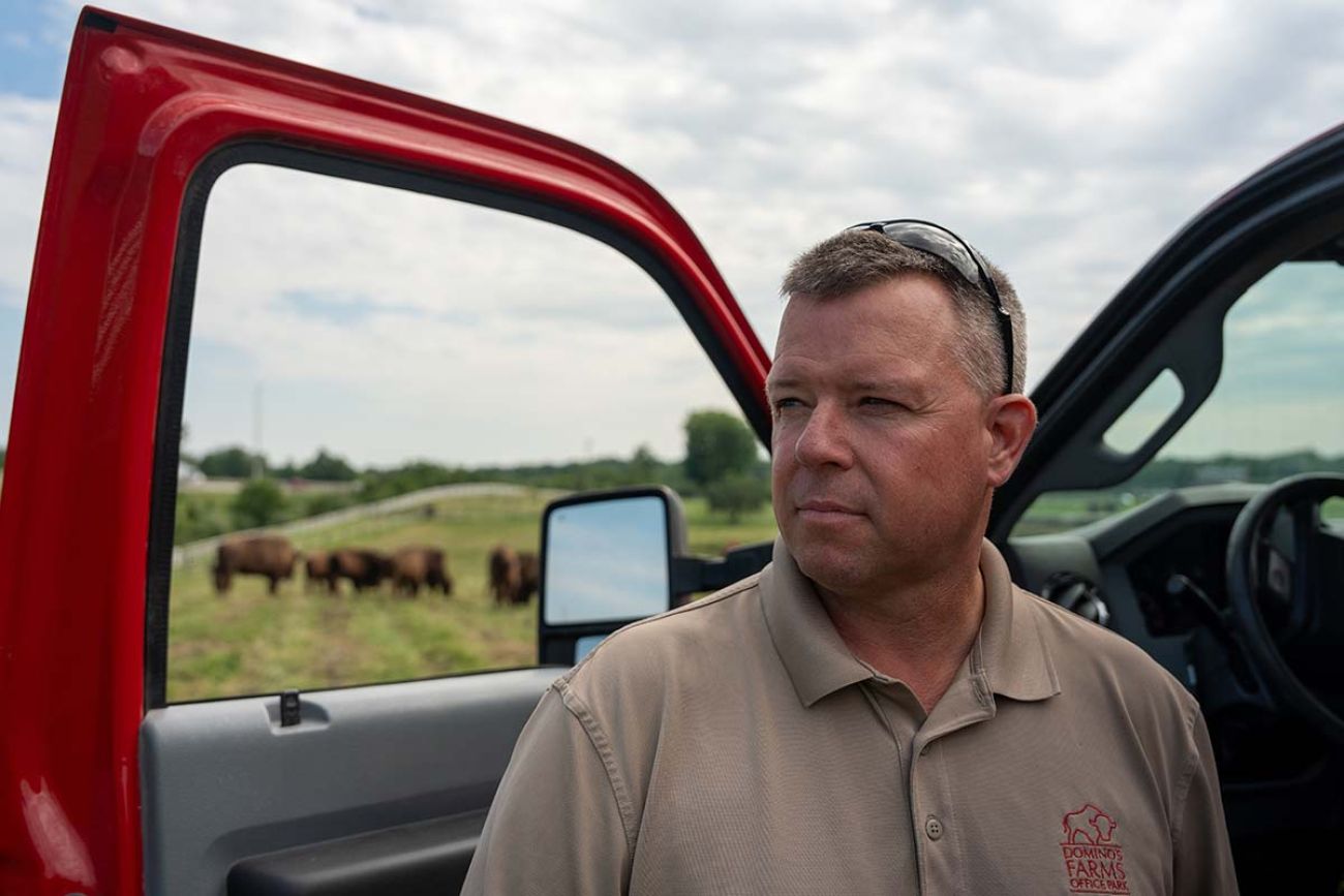 Todd Crocker standing next to a truck. Bison can be seen in the background
