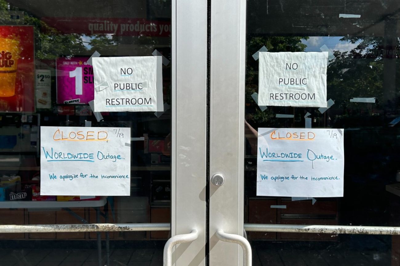 A sign that says "Closed. Worldwide Outage. We apologize for any inconvenience" outside a gas station in Michigan. 