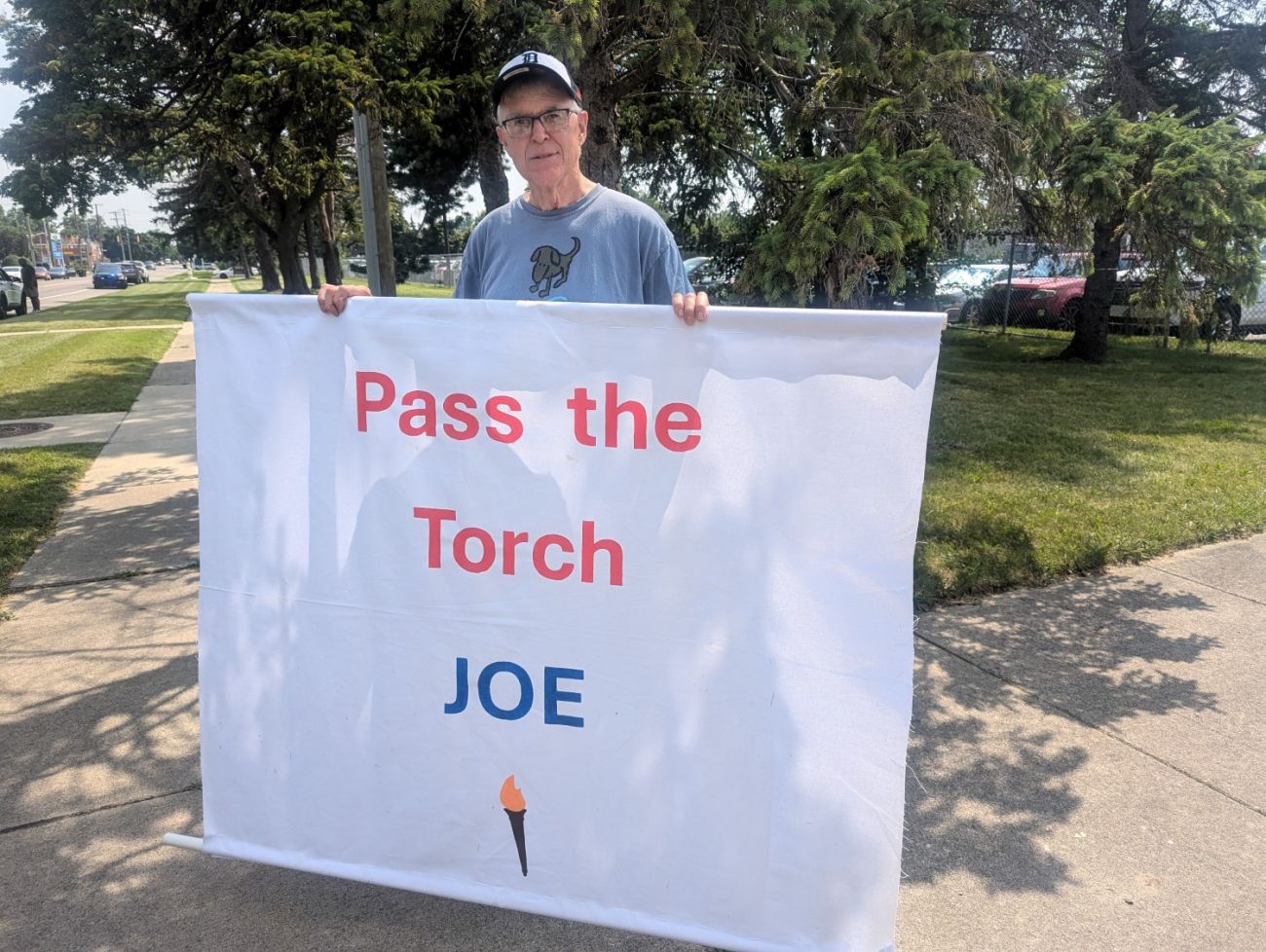 A man holds a "pass the torch Joe" sign