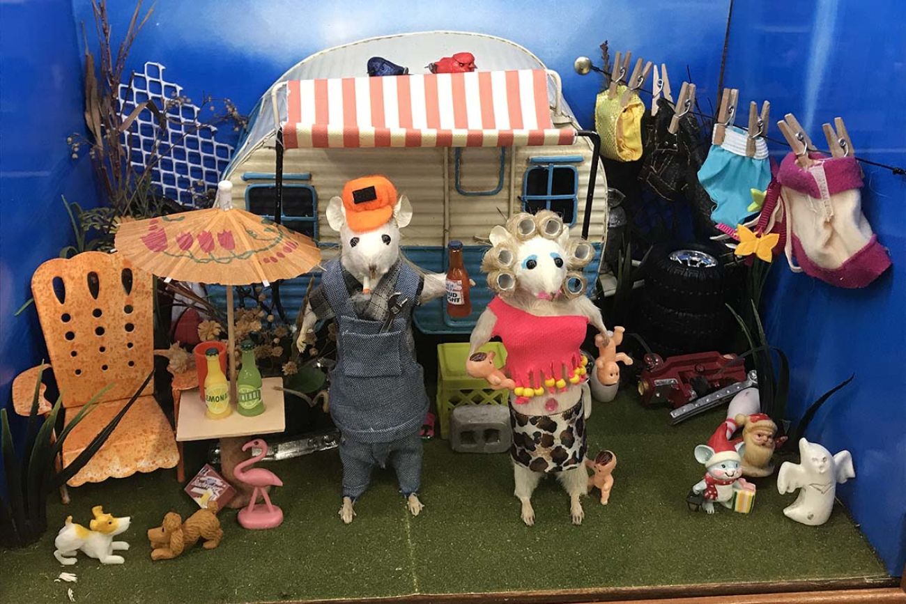 Two taxidermy mice posed in front of a toy camper 