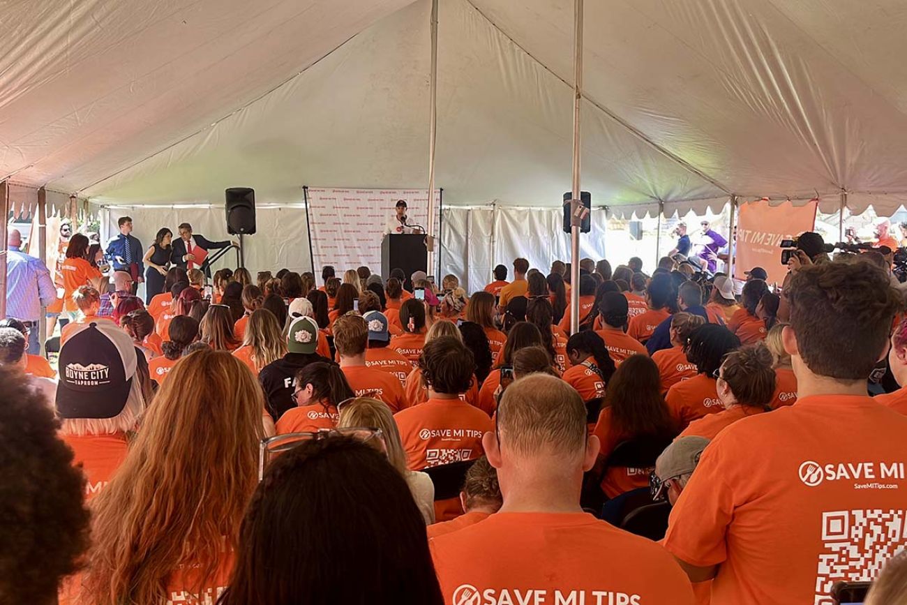 A group of people wearing orange shirts that says "Save MI tips"