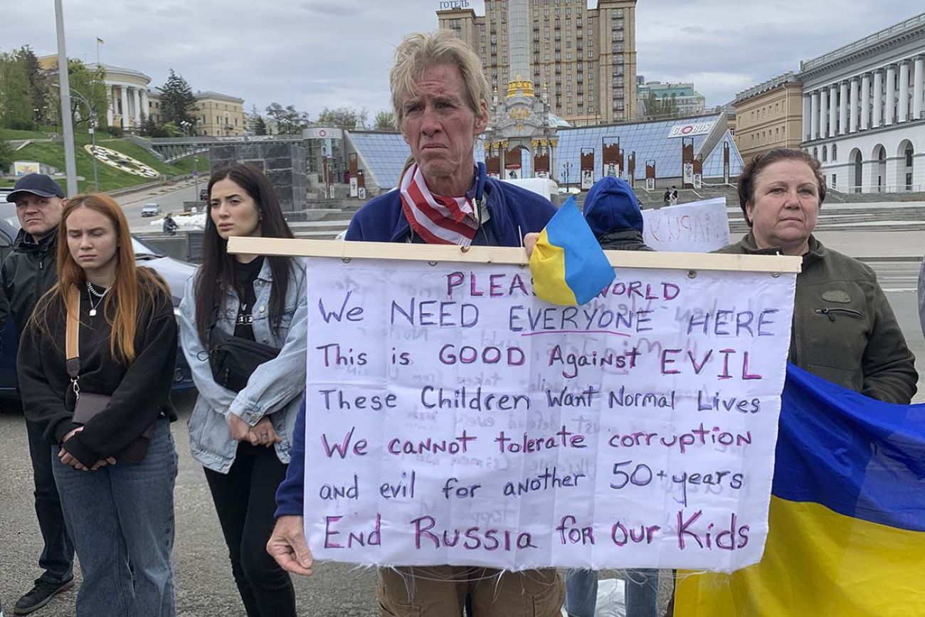 Ryan Wesley Routh holds up a banner during a rally in central Kyiv, Ukraine. It talks about how the war is about good vs evil