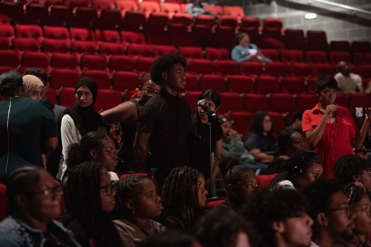 A student standing to speak into a microphone