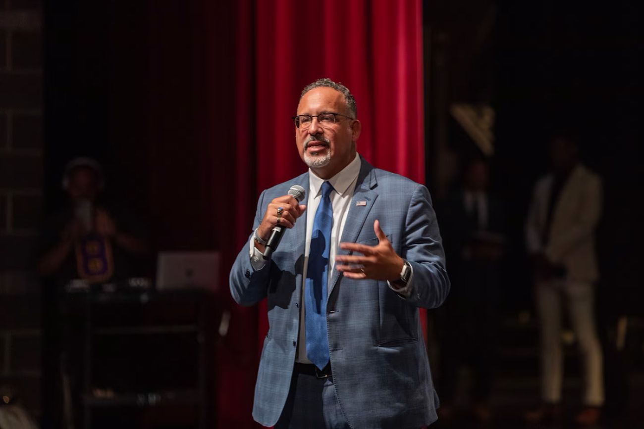 U.S. Secretary of Education Miguel Cardona speaks into a microphone on Cass Technical High School in Detroit 