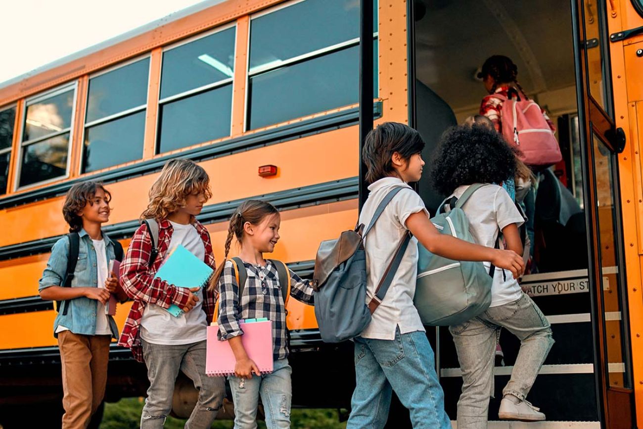 Children go into a yellow school bus