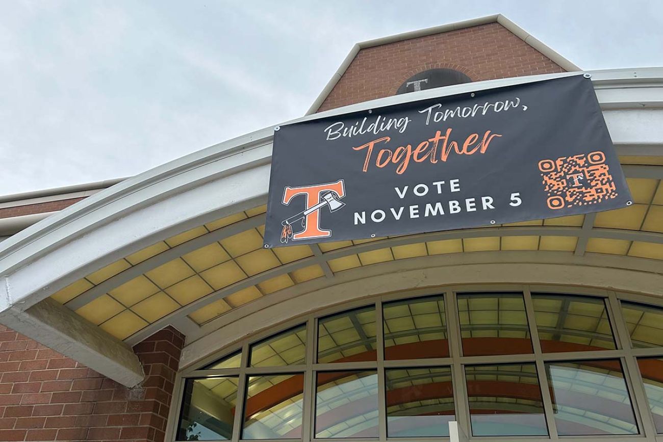 A sign on top of a building that says "Building tomorrow, together. Vote November 5"