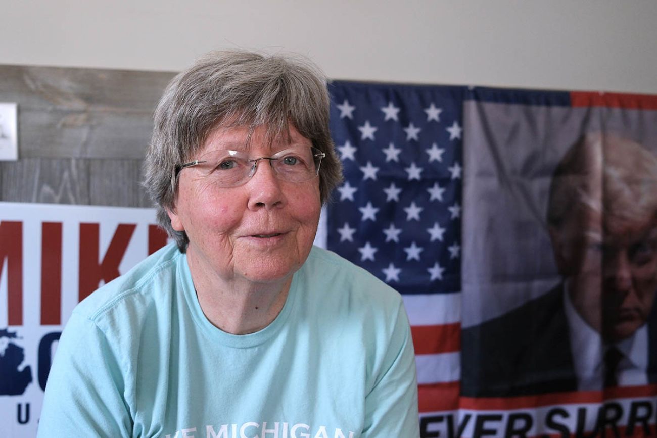 Geri McCaleb sitting in front of signs for Republican candidates