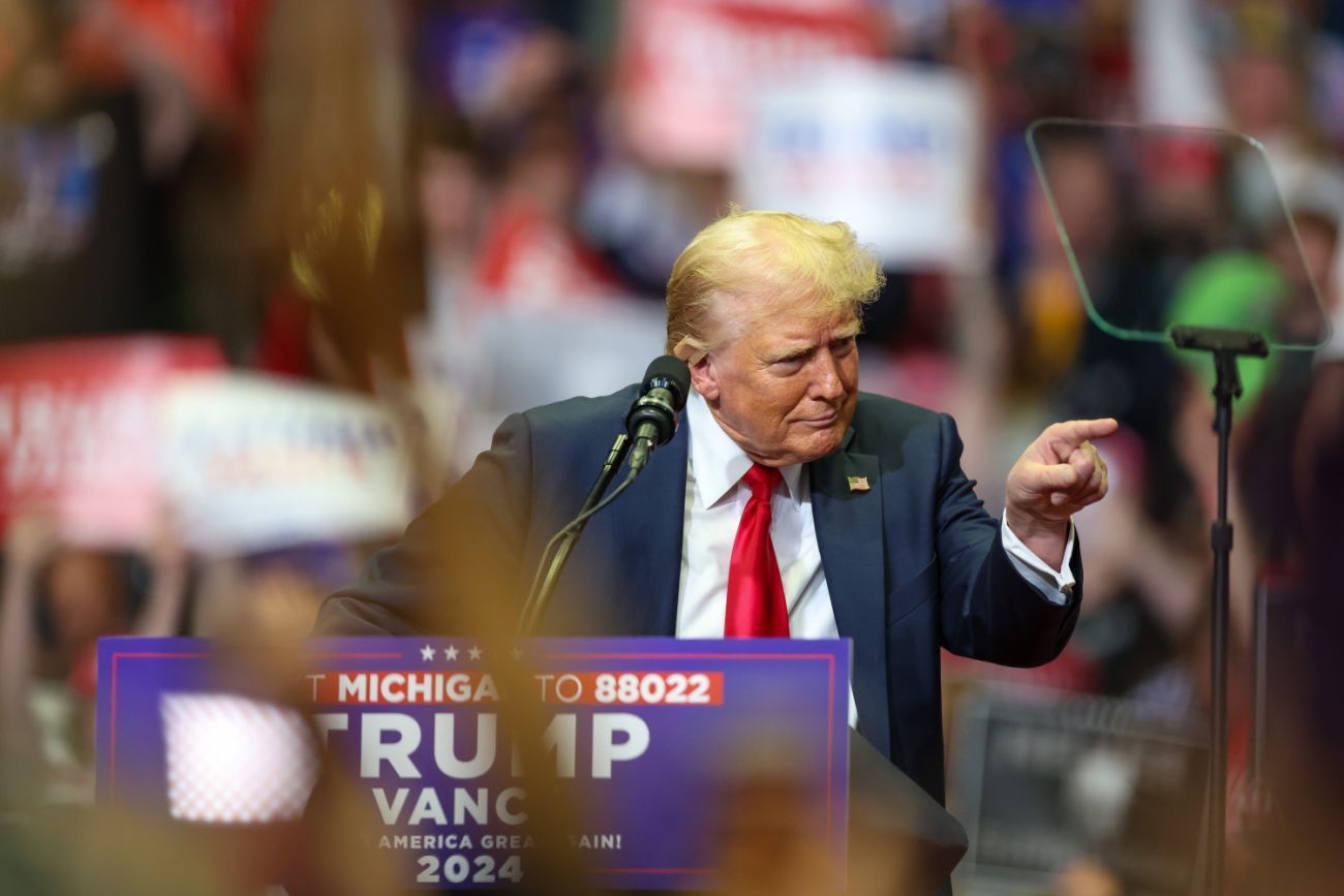 Donald Trump, on stage at a rally, pointing to the audience 