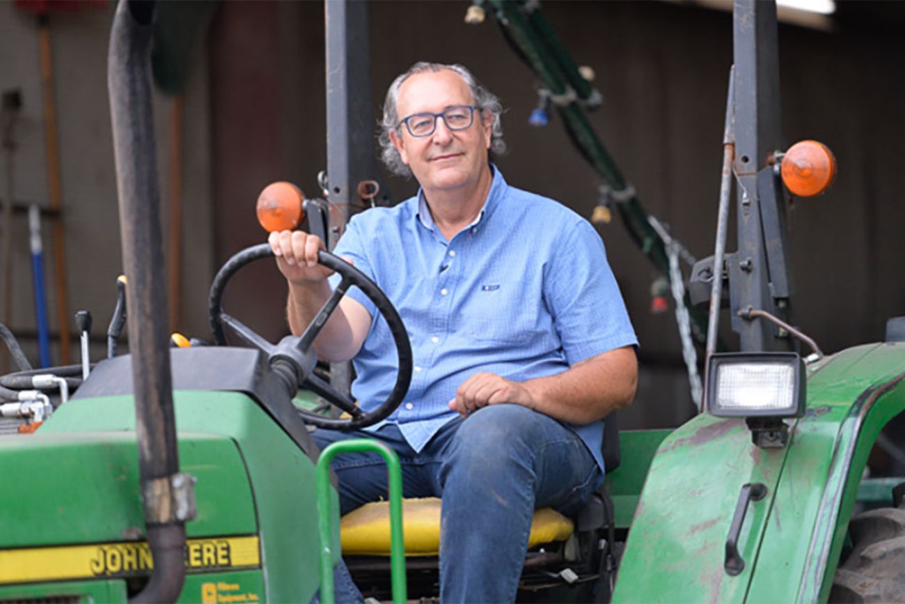 Roger Victory riding a green tractor