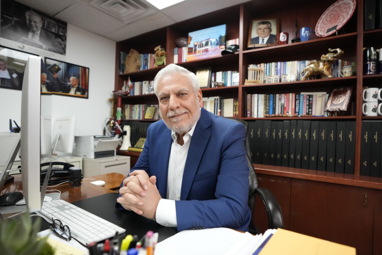 Osama Siblani sits on a chair behind his desk in his office