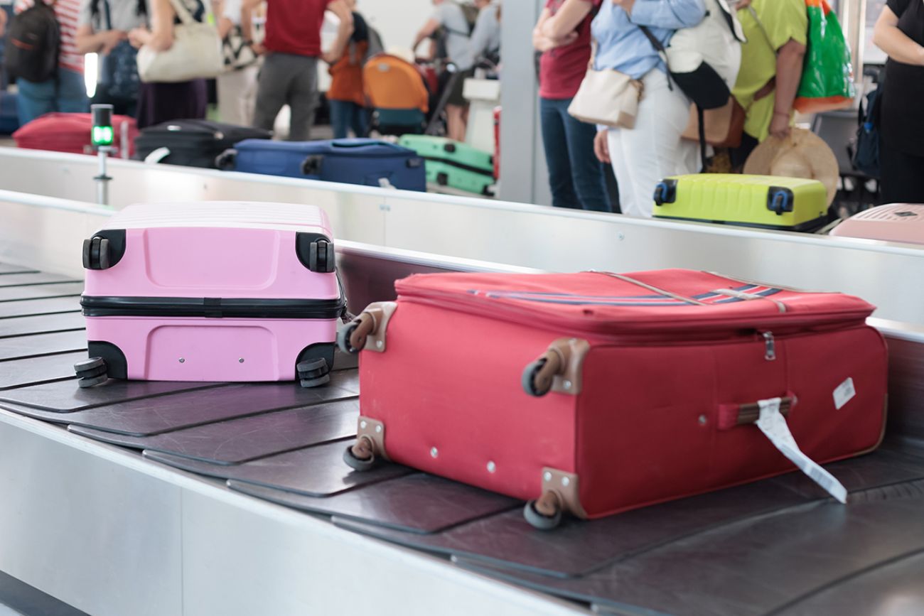 Suitcases on a baggage carousel at an airport during a busy travel day