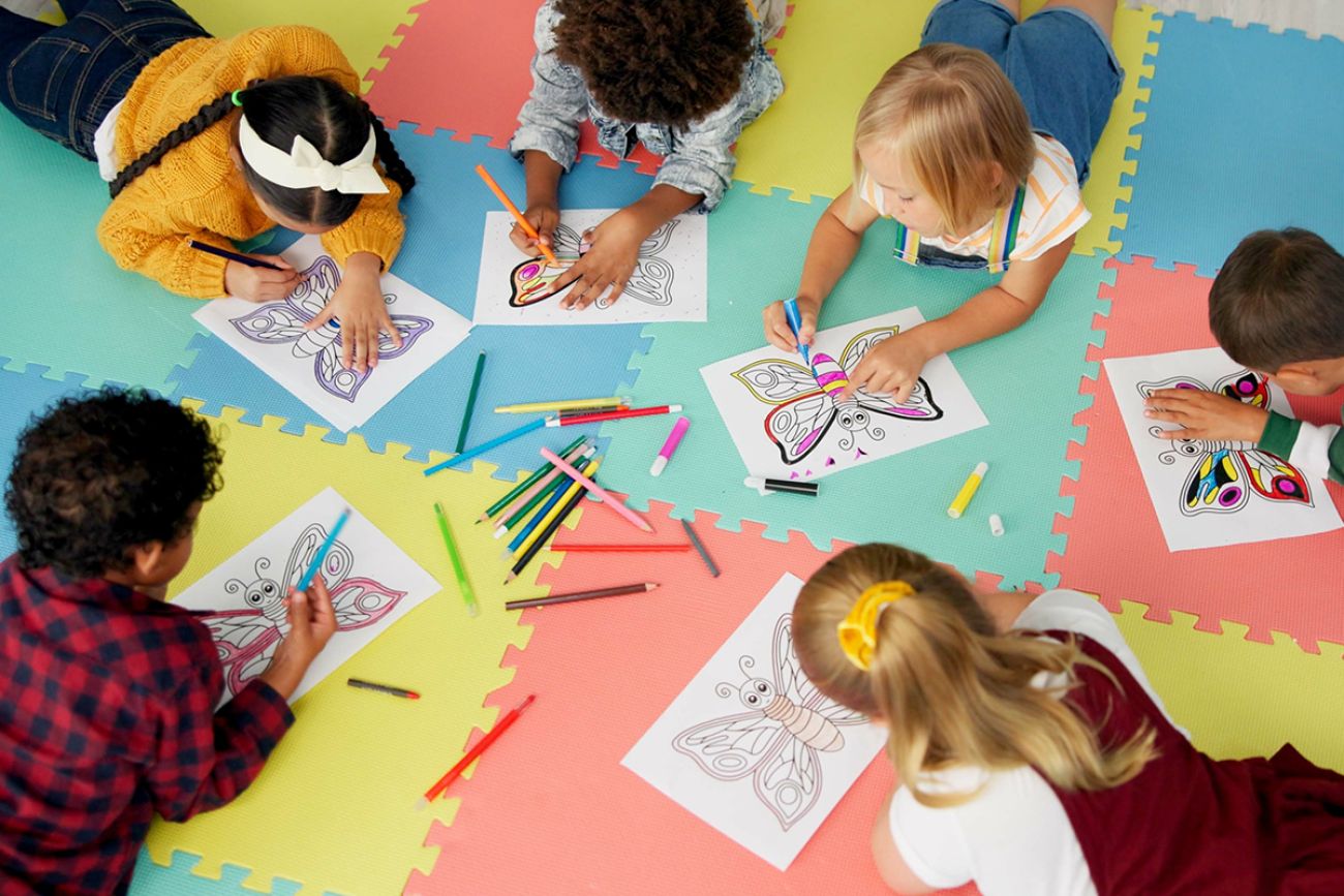 A group of kids drawing on the floor