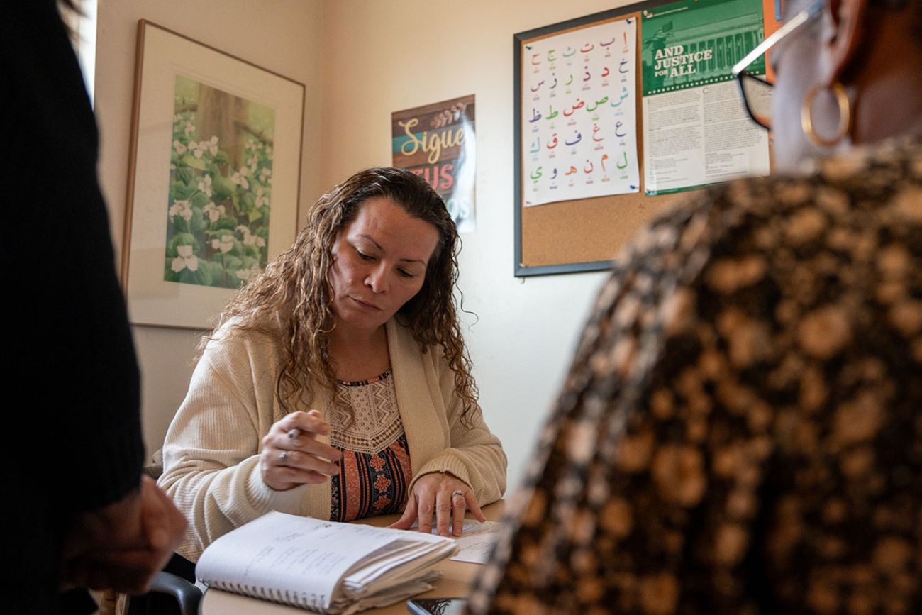 Melissa Rios filling out paperwork on the desk. 