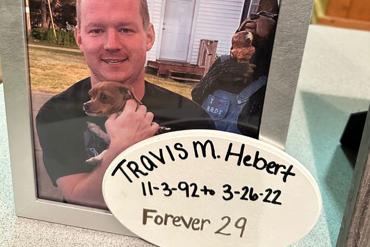 A photo of Travis Hebert. He is holding a dog. 