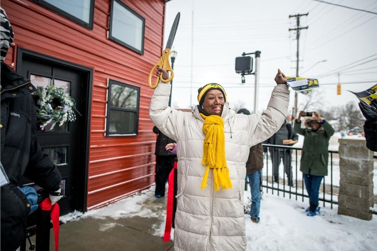 Woman cuts the ribbon on housing project